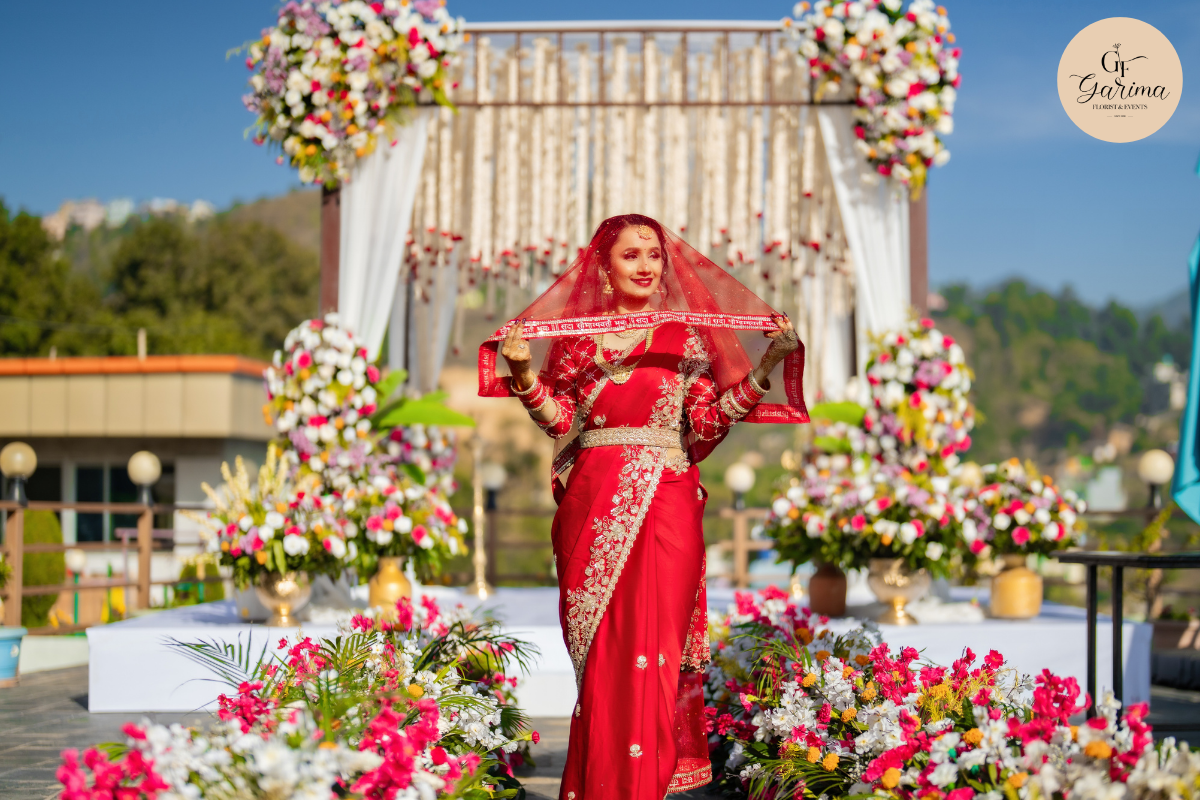 Bride standing beneath floral wedding decor at an outdoor wedding in Nepal