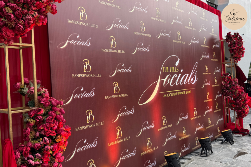 floral event backdrop with a large clock-themed centerpiece and pink and white flower arrangements