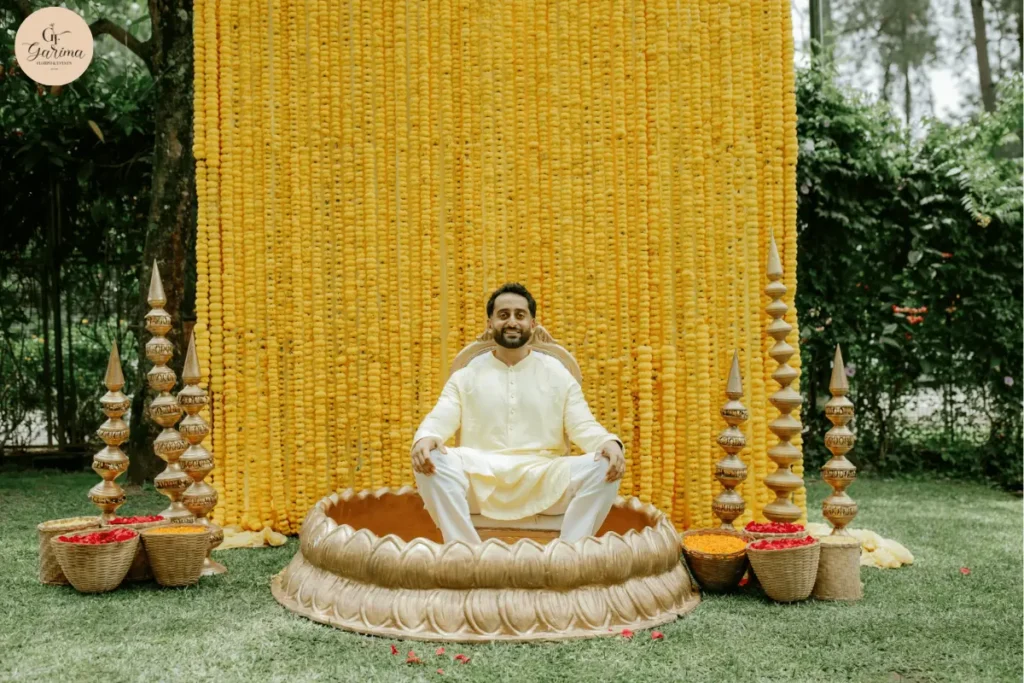 outdoor haldi setup with yellow marigold backdrop and traditional seating