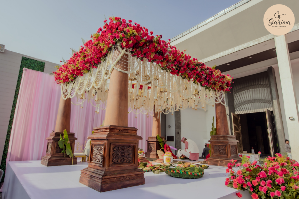 wedding ceremony aisle with floral arrangements, guest seating and flower backdrop