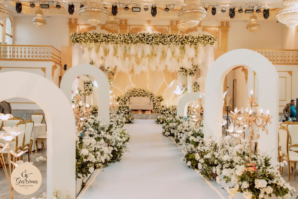 indoor wedding venue decorated with red floral arrangements by garima glorist & events