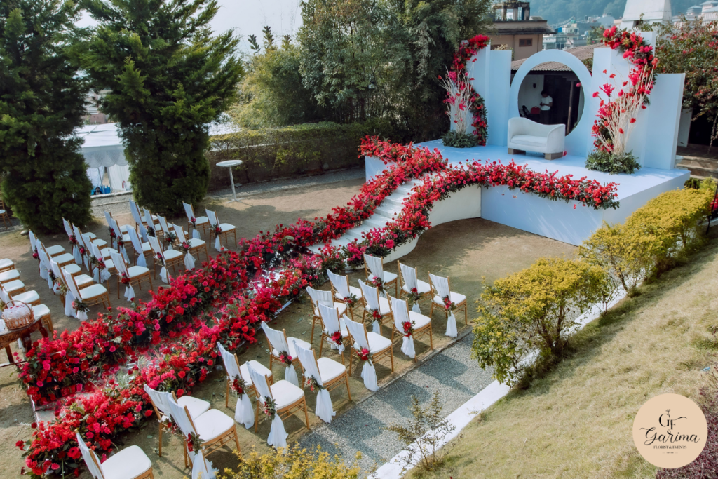 wedding mandap decorated with red and pink flowers, draping and hanging details